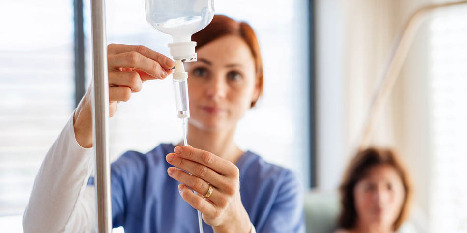 A nurse administers an IV drip for a patient.